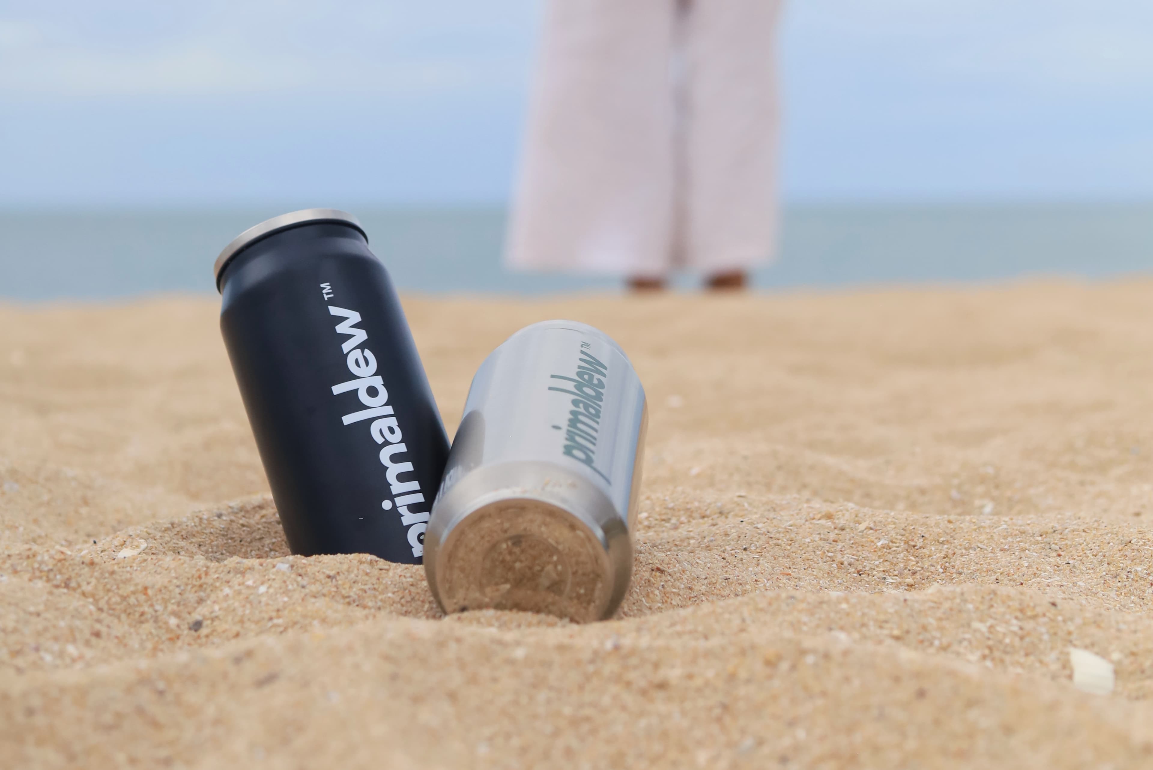 Primaldew tumblers on a sandy beach — bringing daily nutrition wherever life takes you